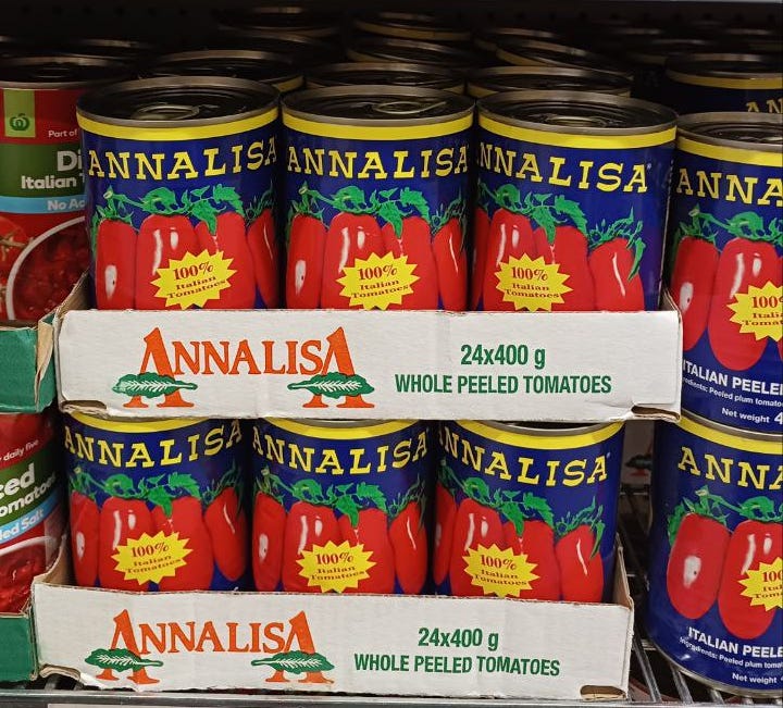 Primo piano dello scaffale di un supermercato australiano riempito di barattoli di pomodori pelati Annalisa.