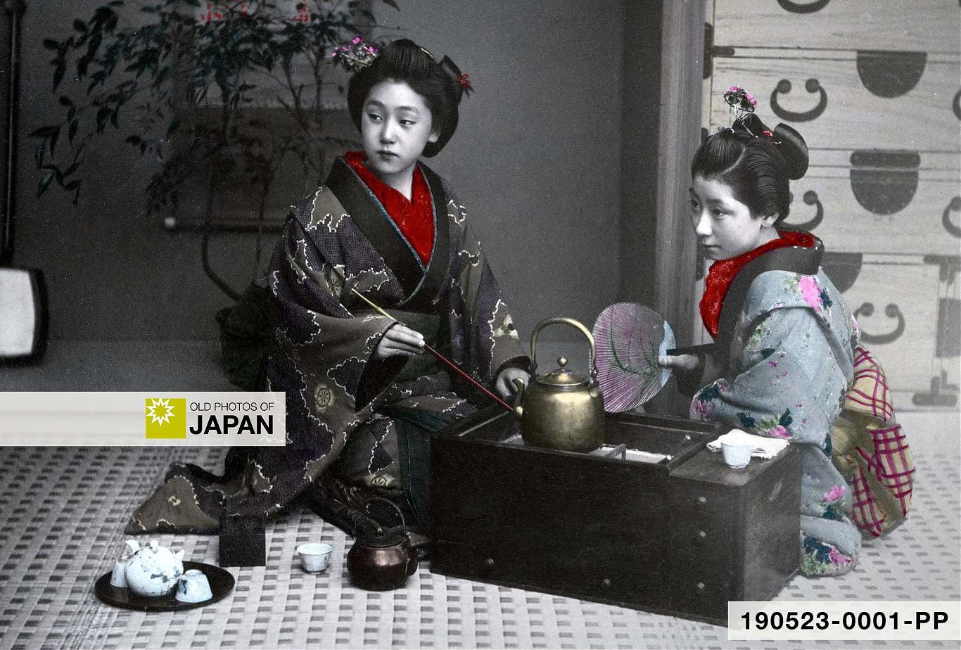 Two Japanese women around a hibachi charcoal brazier, 1890s