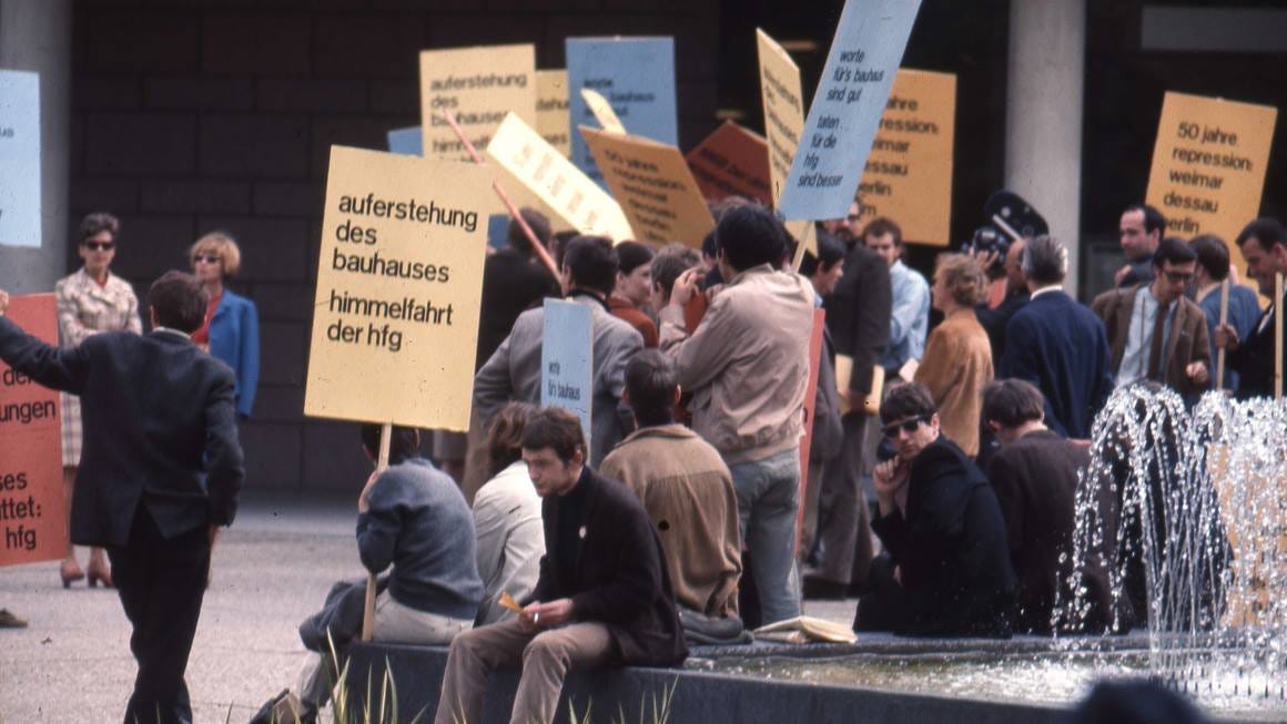 Estudantes seguram cartazes coloridos e protestam contra o fechamento da HfG Ulm. Estudantes seguram cartazes coloridos e protestam contra o fechamento da HfG Ulm.