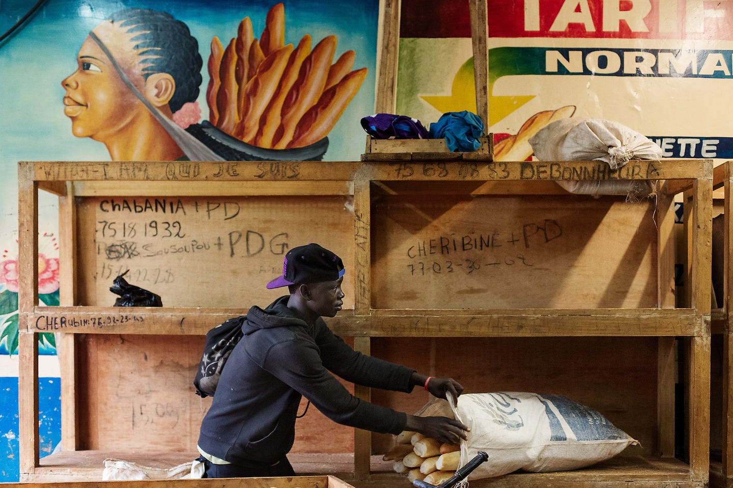 “October 25th 2013, in a Muslim district called 5 kilo in Bangui, a young man buys some bread in a local bakery to sell on the streets. Since the Seleka have taken power in the Central African Republic, people struggle to survive as there are no more jobs in the city because of weak business environment. The youth have no other choice but to find informal jobs to sustain themselves.” From ‘On est ensemble’. © Camille Lepage