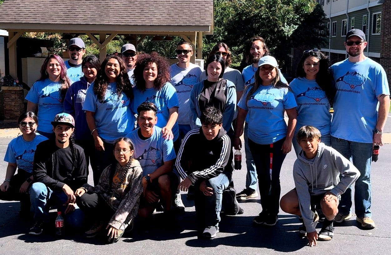 A group of volunteers kneel and stand together as a group posing for a picture.