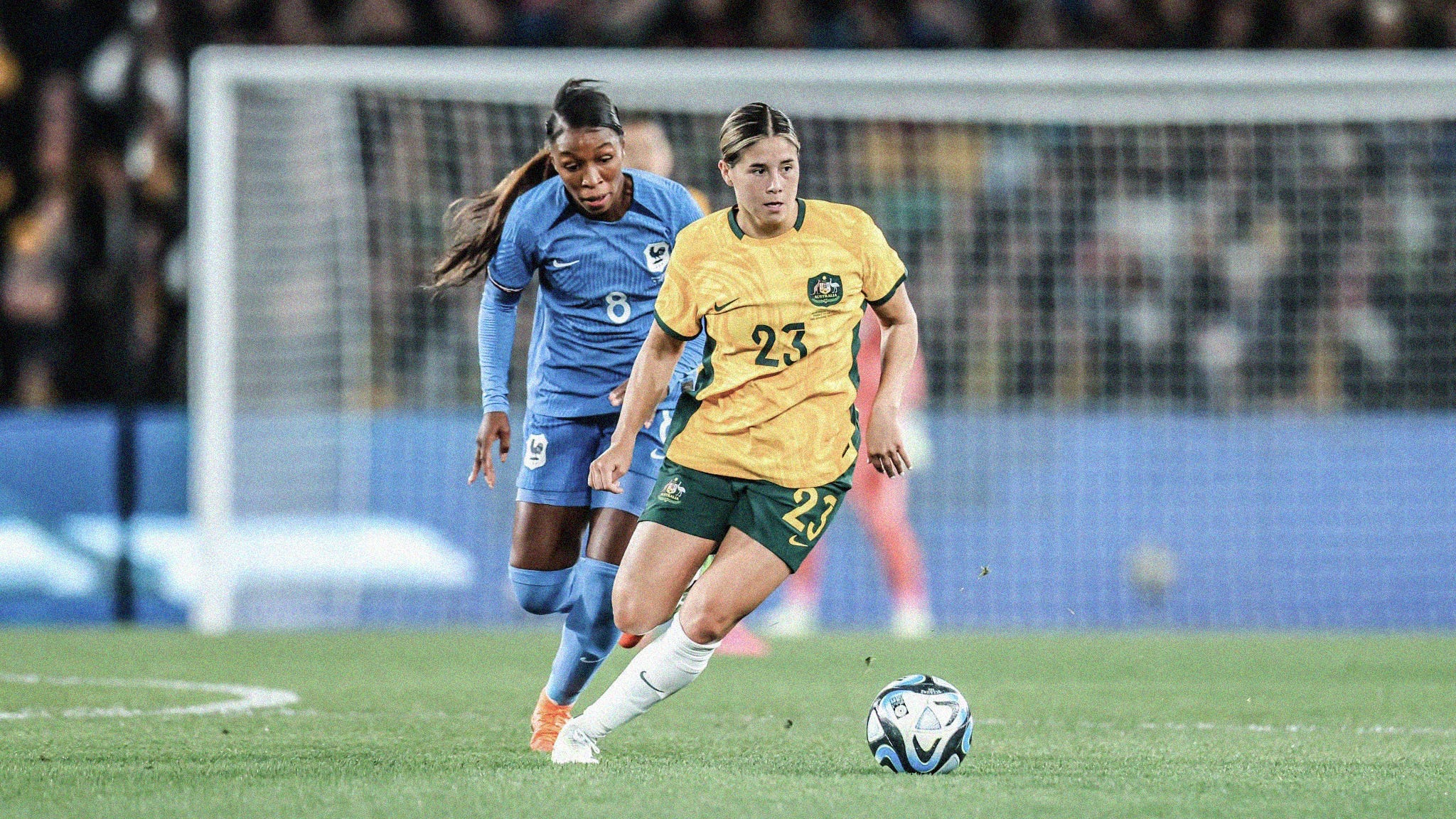 A photo of Australia's Kyra Cooney-Cross dribbling away from a French defender
