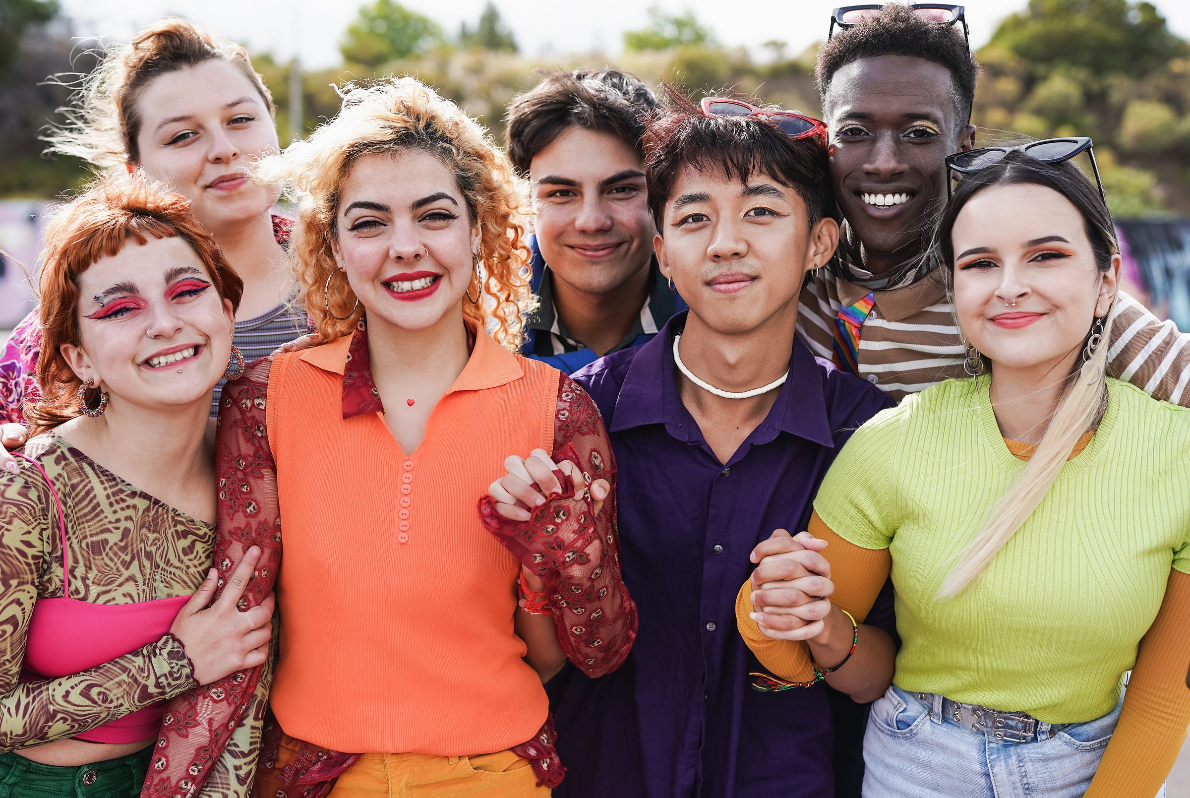 Diverse group of young people smiling and holding hands