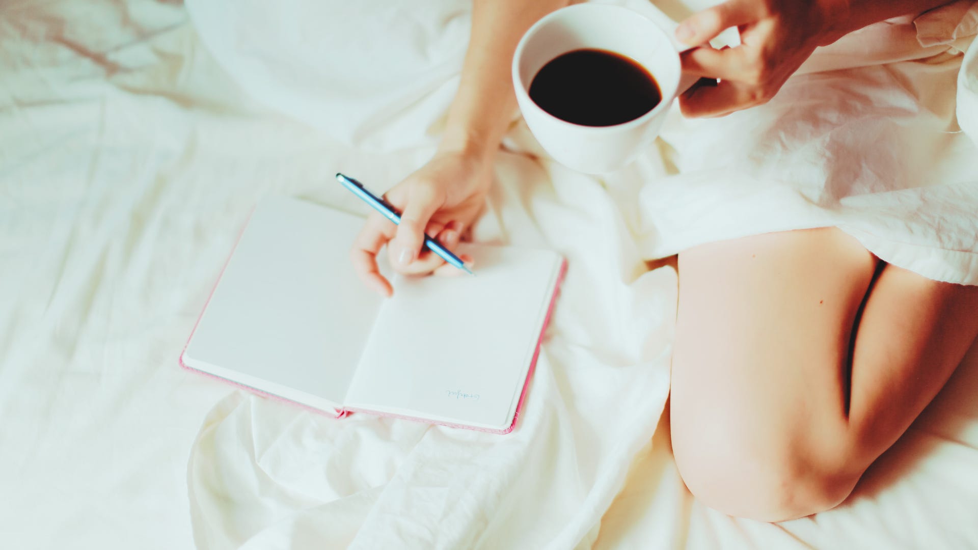 woman in bed with cup of coffee gratitude journaling