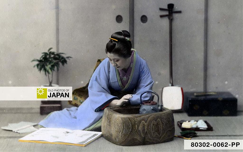 A young Japanese woman is reading while warming her right hand at a hibachi with a kettle, 1890s A young Japanese woman is reading while warming her right hand at a hibachi with a kettle, 1890s