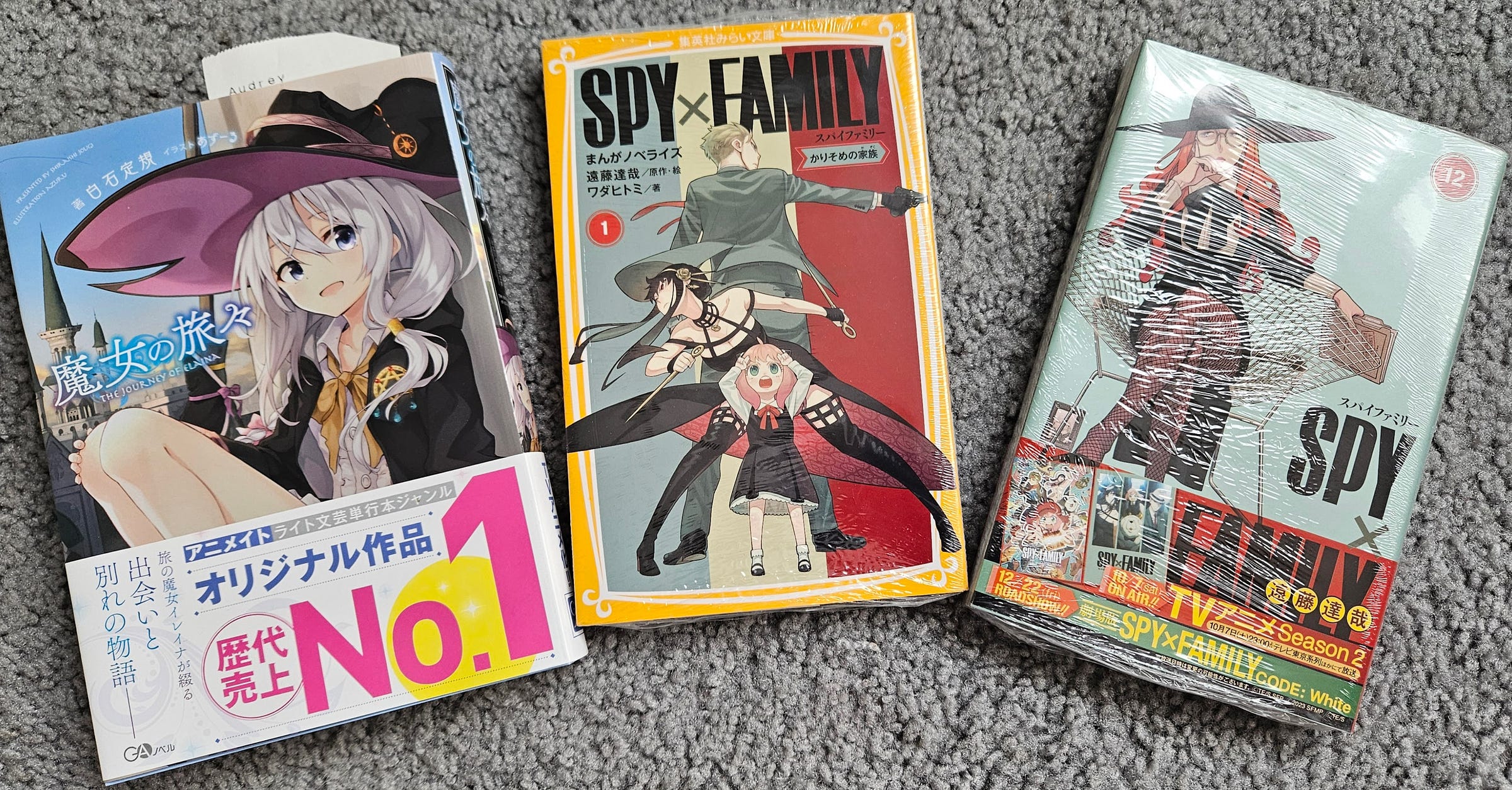 A photo of the light novel for The Journey of Eleana v1 , as well as the manga of Spy X Family v1 and 12.