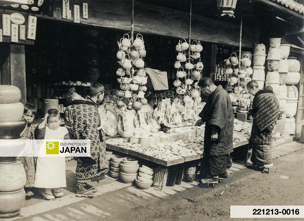 Japanese boy carrying a younger sibling at a porcelain store, 1910s