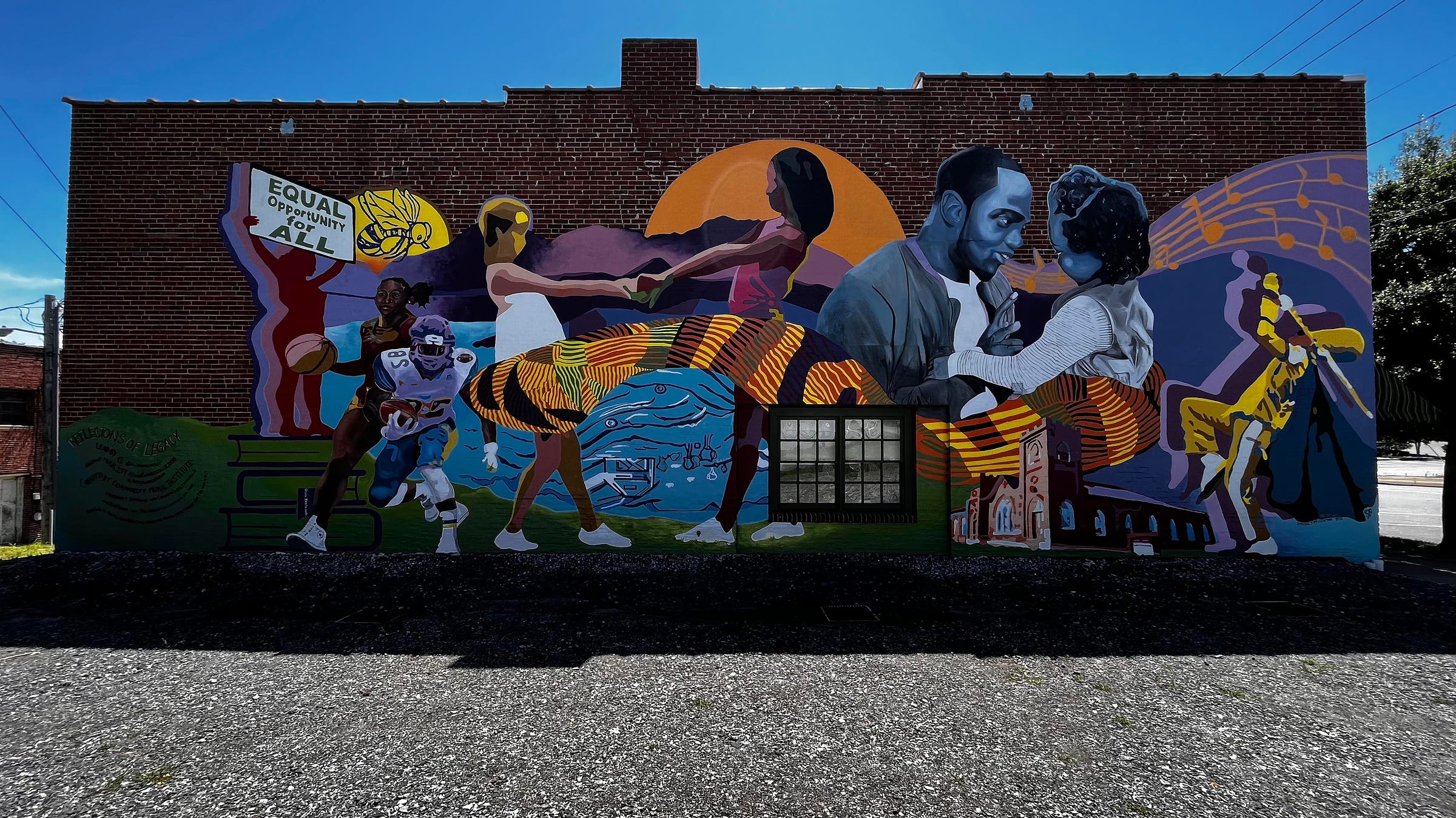 Image of a mural featuring several figures with dark skin tones playing sports, dancing, protesting for equal rights, and playing musical instruments.
