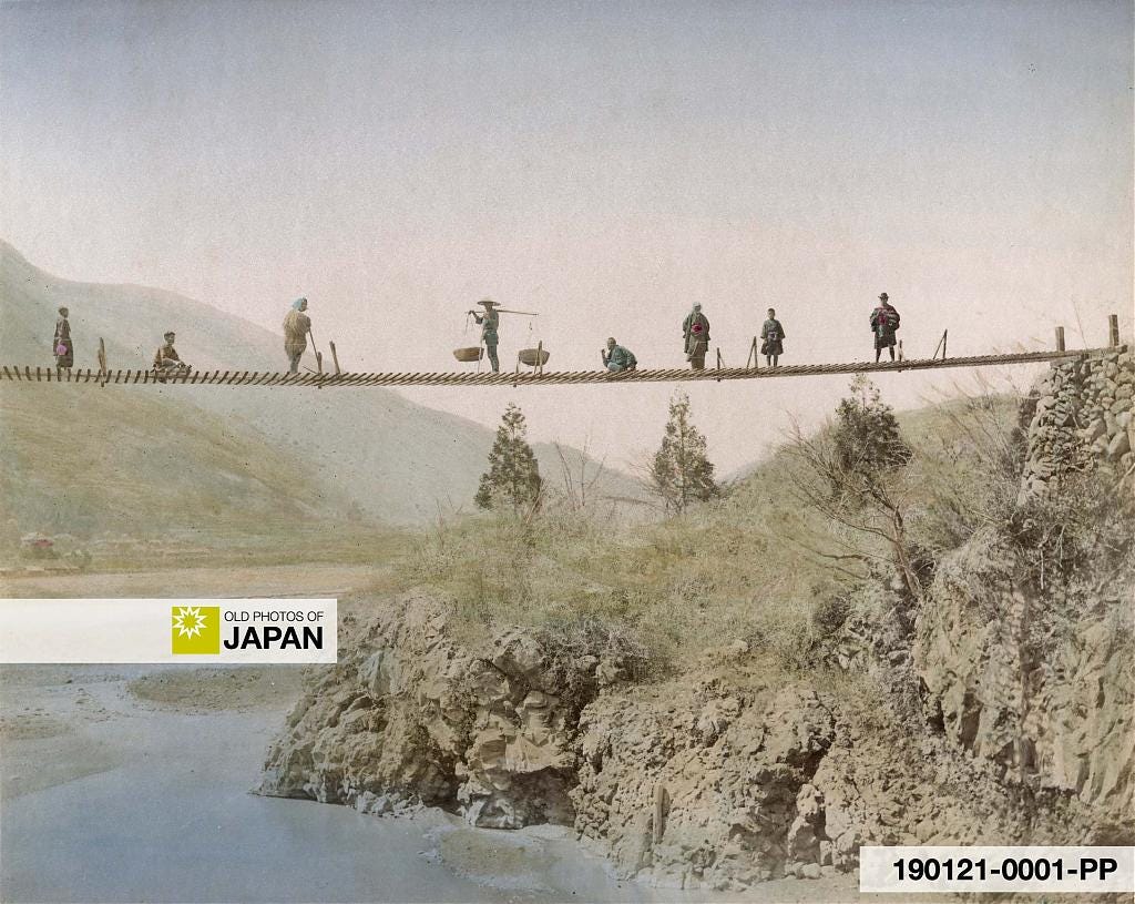 Hand colored albumen print of Japanese travelers posing on a suspension bridge, ca. 1880s