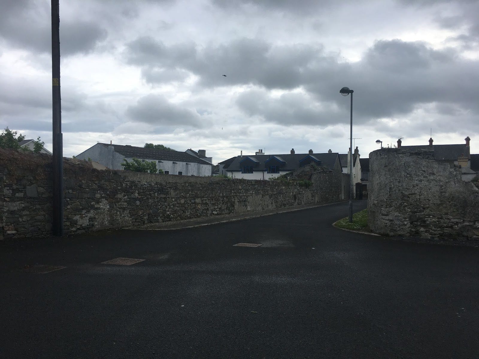Intersection of two streets, each surrounded by tall rock walls.Portaferry, Ireland. May 2019. Photograph by the author.