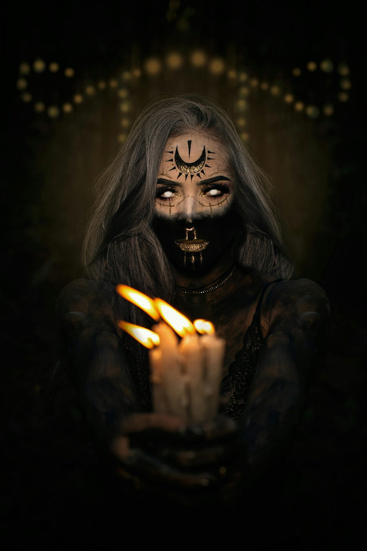 Woman in a Halloween Costume and Makeup Holding Burning Candles Woman in a Halloween Costume and Makeup Holding Burning Candles