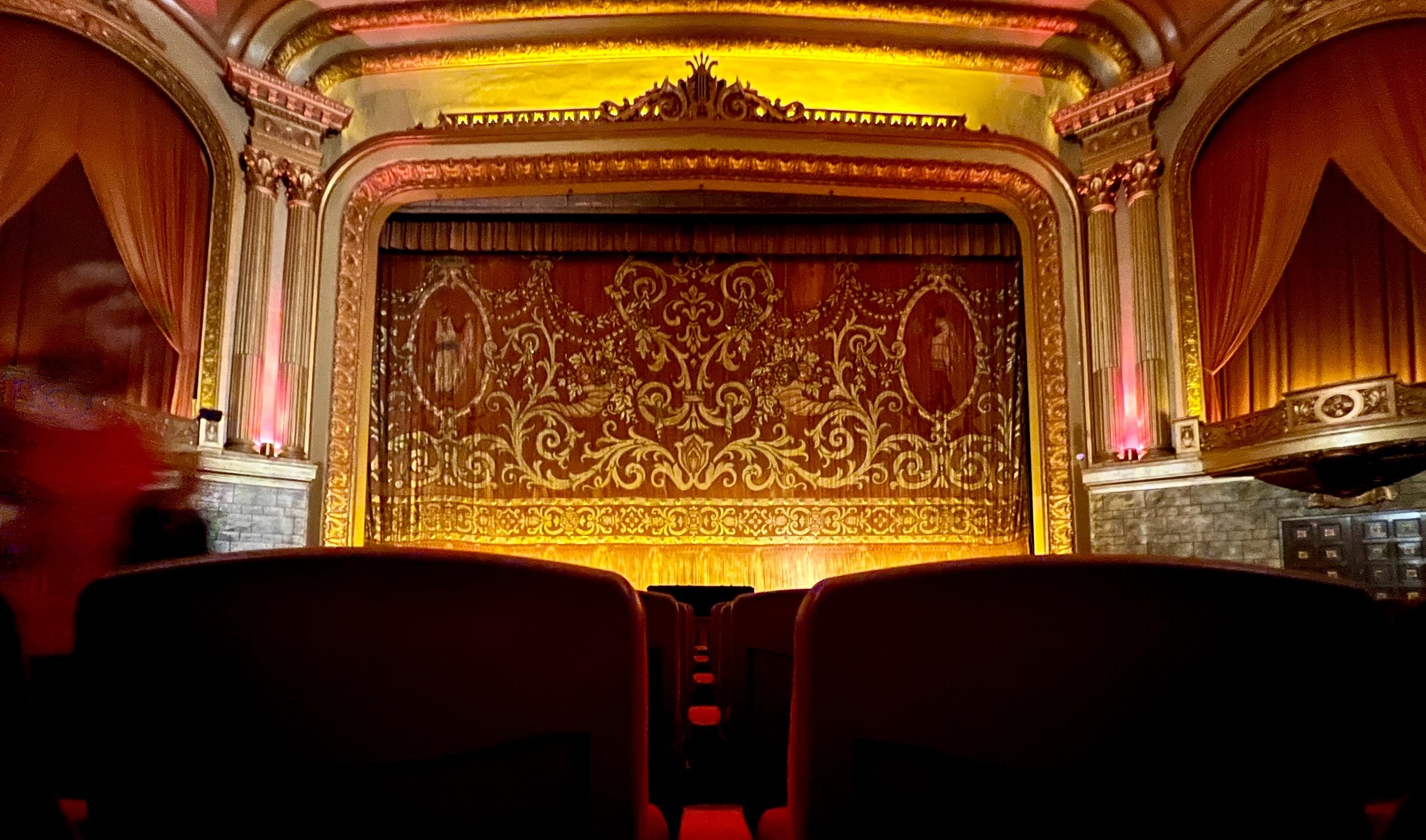 The interior of the Grand Lake Theater in Oakland, California. A red velvet curtain, ornately decorated sits surrounded by a lavishly ornamented frame. The interior of the Grand Lake Theater in Oakland, California. A red velvet curtain, ornately decorated sits surrounded by a lavishly ornamented frame.