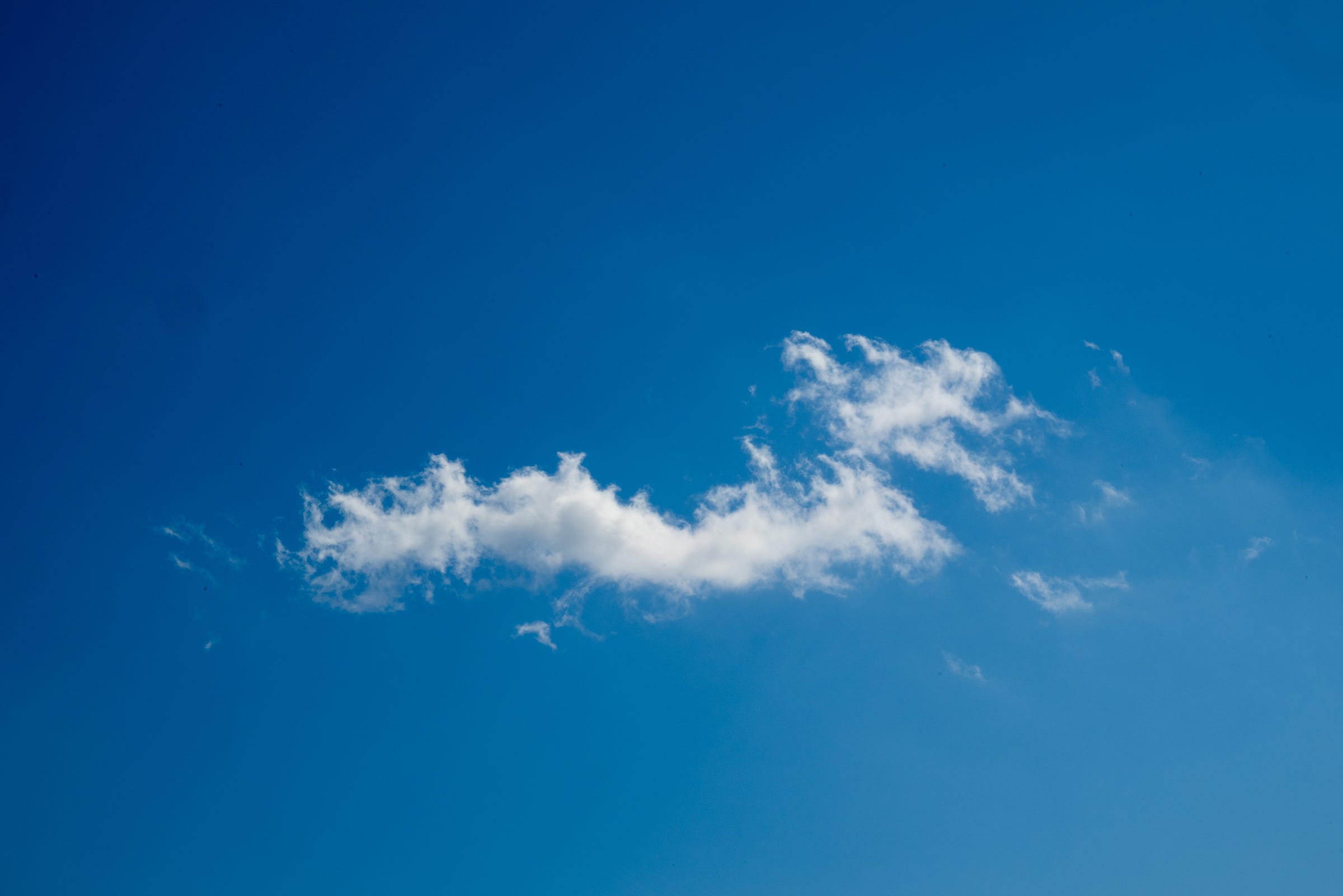 Bright blue sky with a single cloud formation