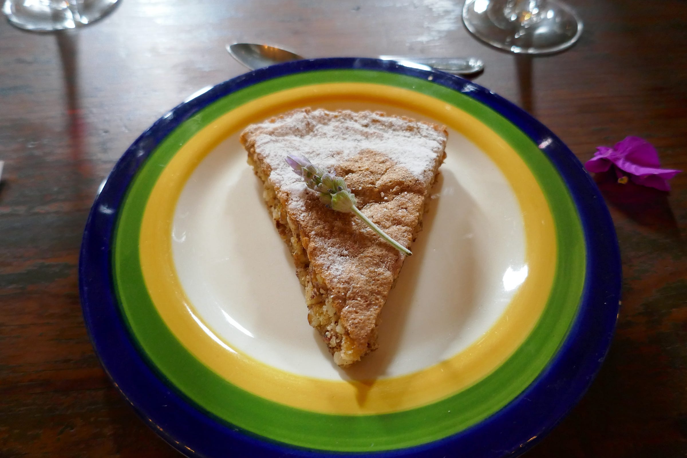 A slice of pie on a plate rimmed in dark blue, green, and yellow with a white center