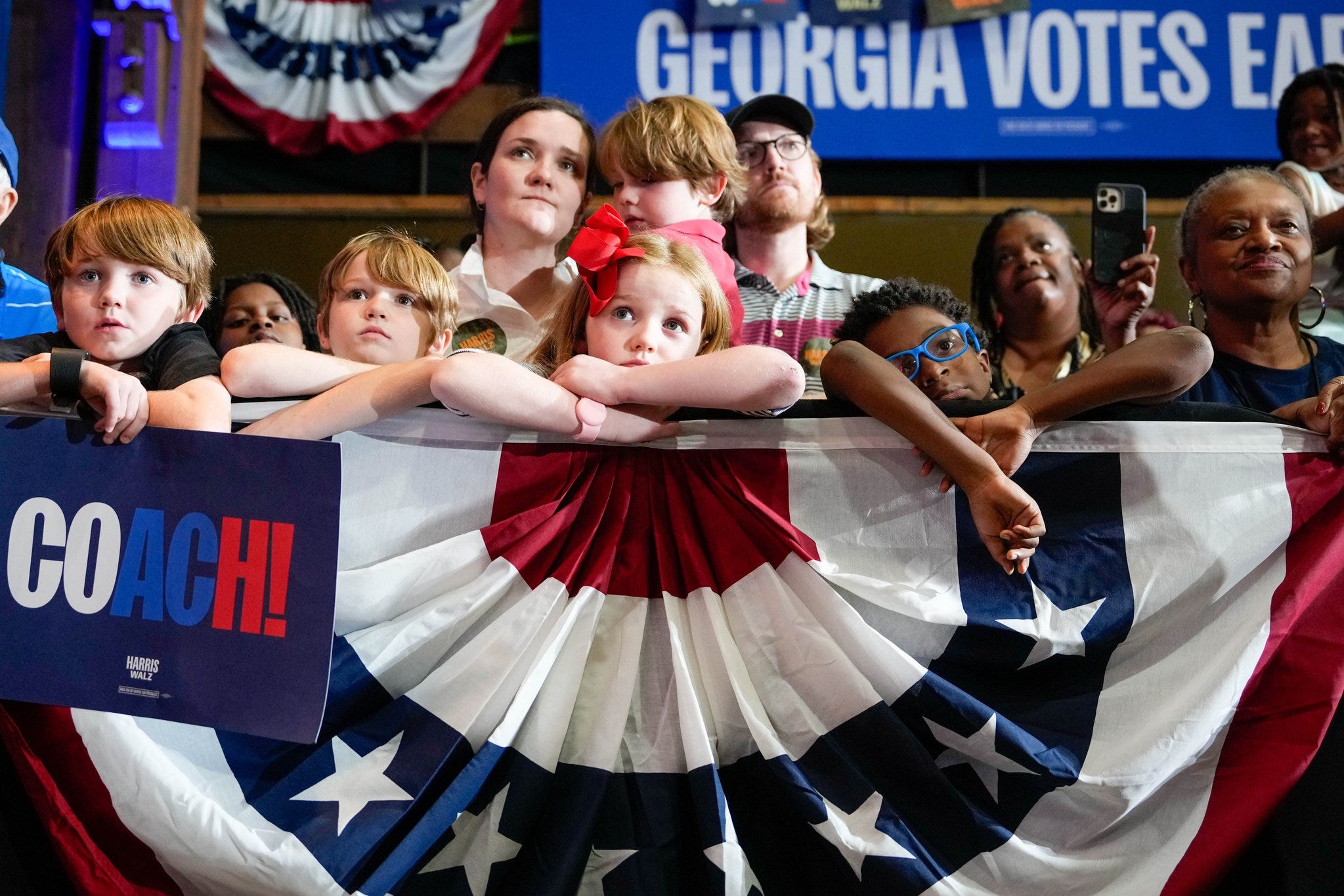 Photo of some somber children, attending a Tim Walz rally