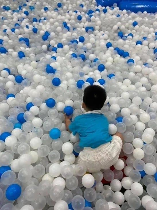 A little boy playing with colored balls at Kidzooona