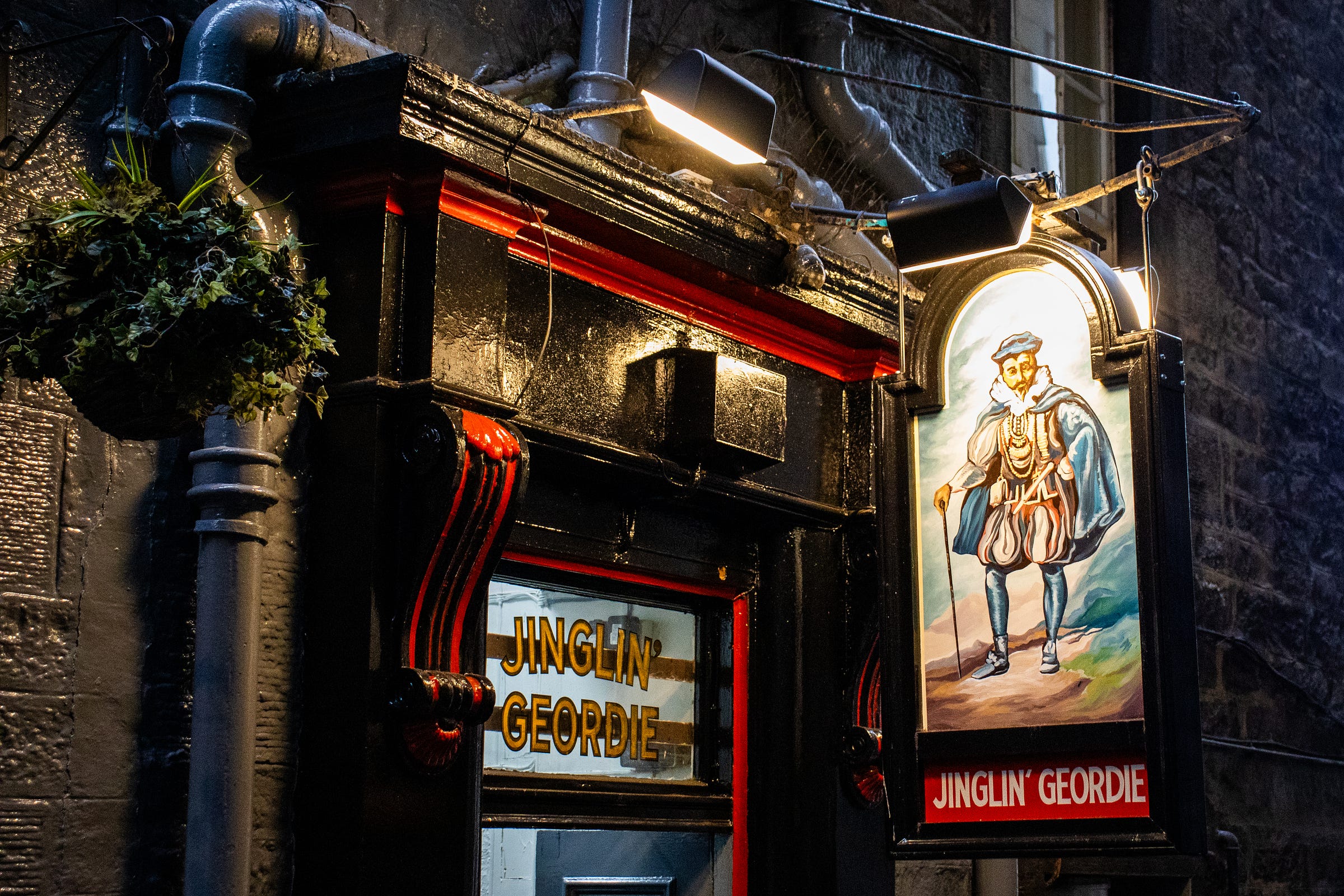 Pub sign depicting George Heriot in his finery, with a hanging basket next to the sign with some free ivy in it.