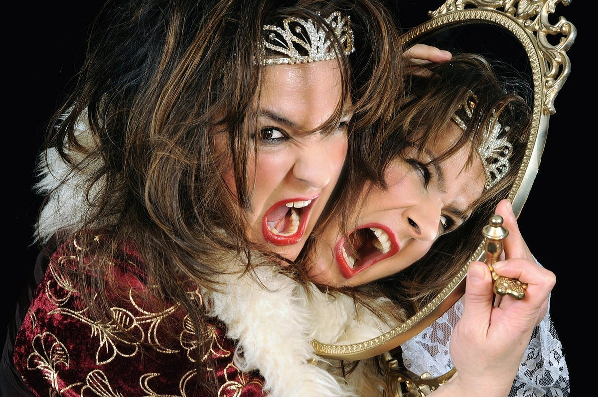 Angry woman in a tiara, dressed like a queen, with her face next to a mirror screaming