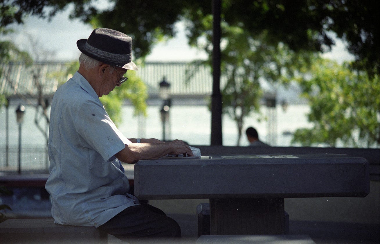 Older man sitting at park table