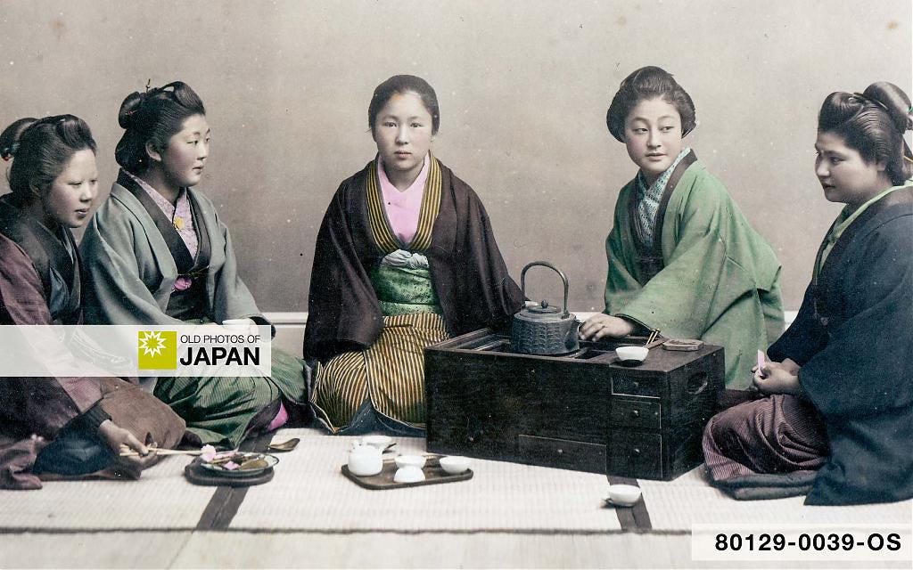 Japanese women posing around an oblong hibachi with drawers Japanese women posing around an oblong hibachi with drawers