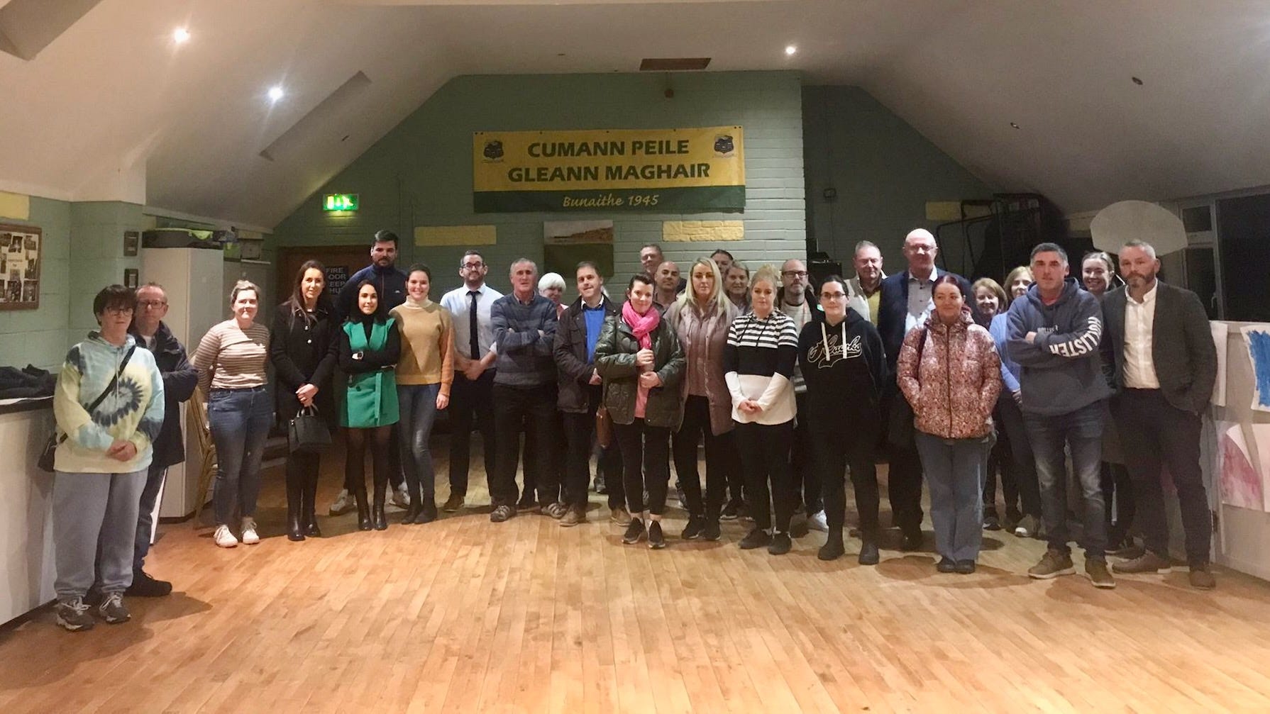 A photograph of a large number of residents affected by flooding in Glanmire after a meeting on the matter, with elected representatives present.