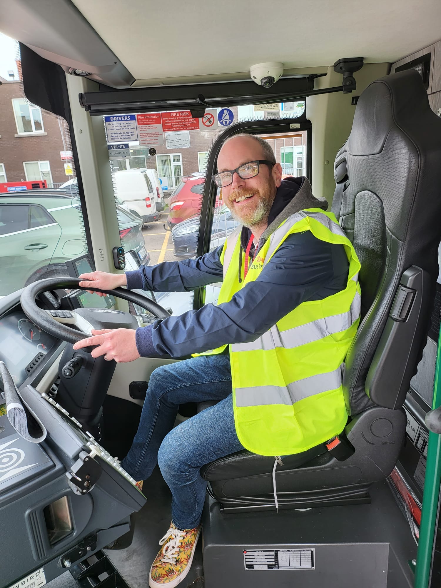 Cllr Oliver Moran sitting in the drivers seat of a bus.