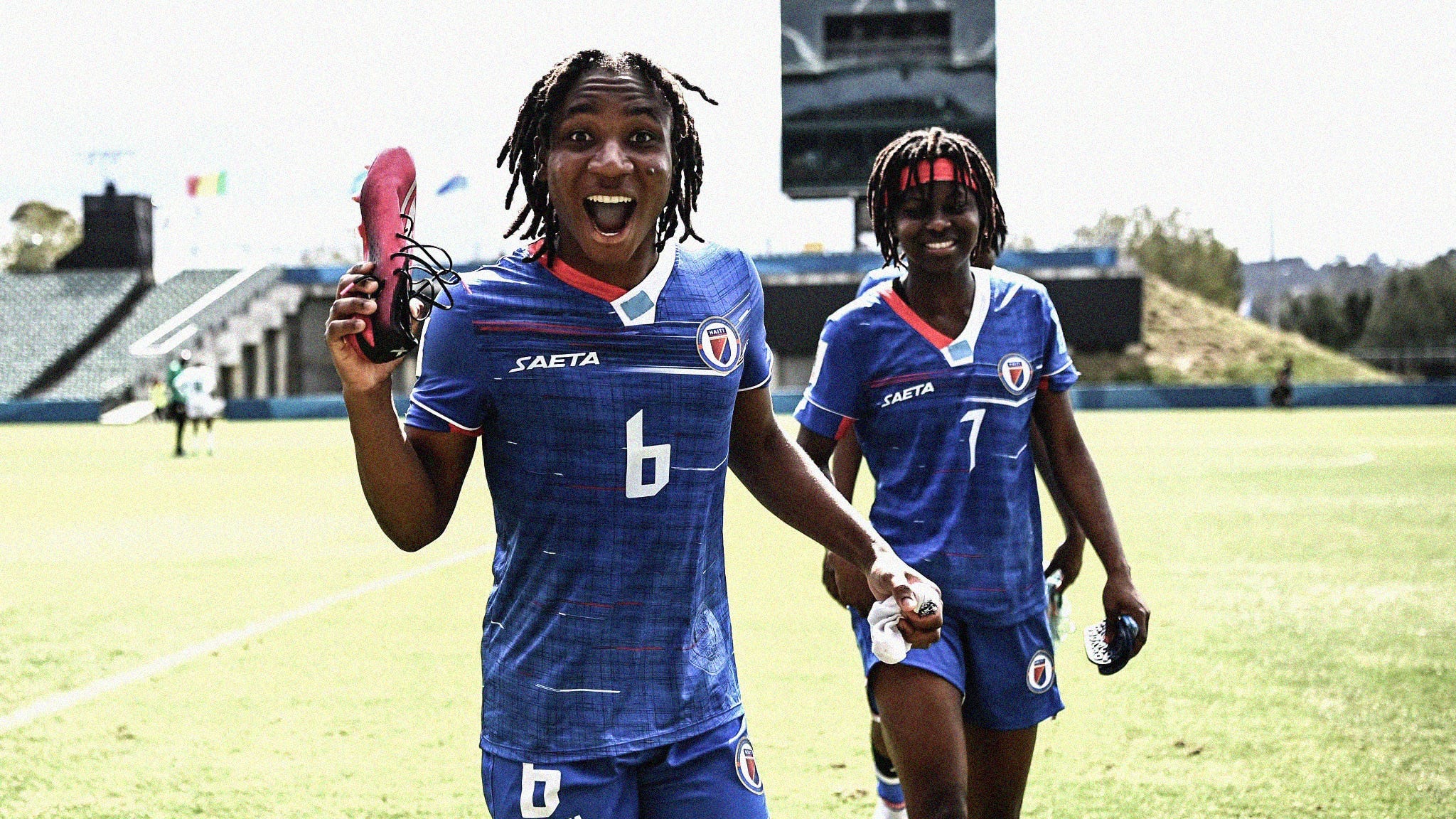 A photo of Haiti's Melchie Dumornay smiling at the camera while holding a pink boot in her right hand
