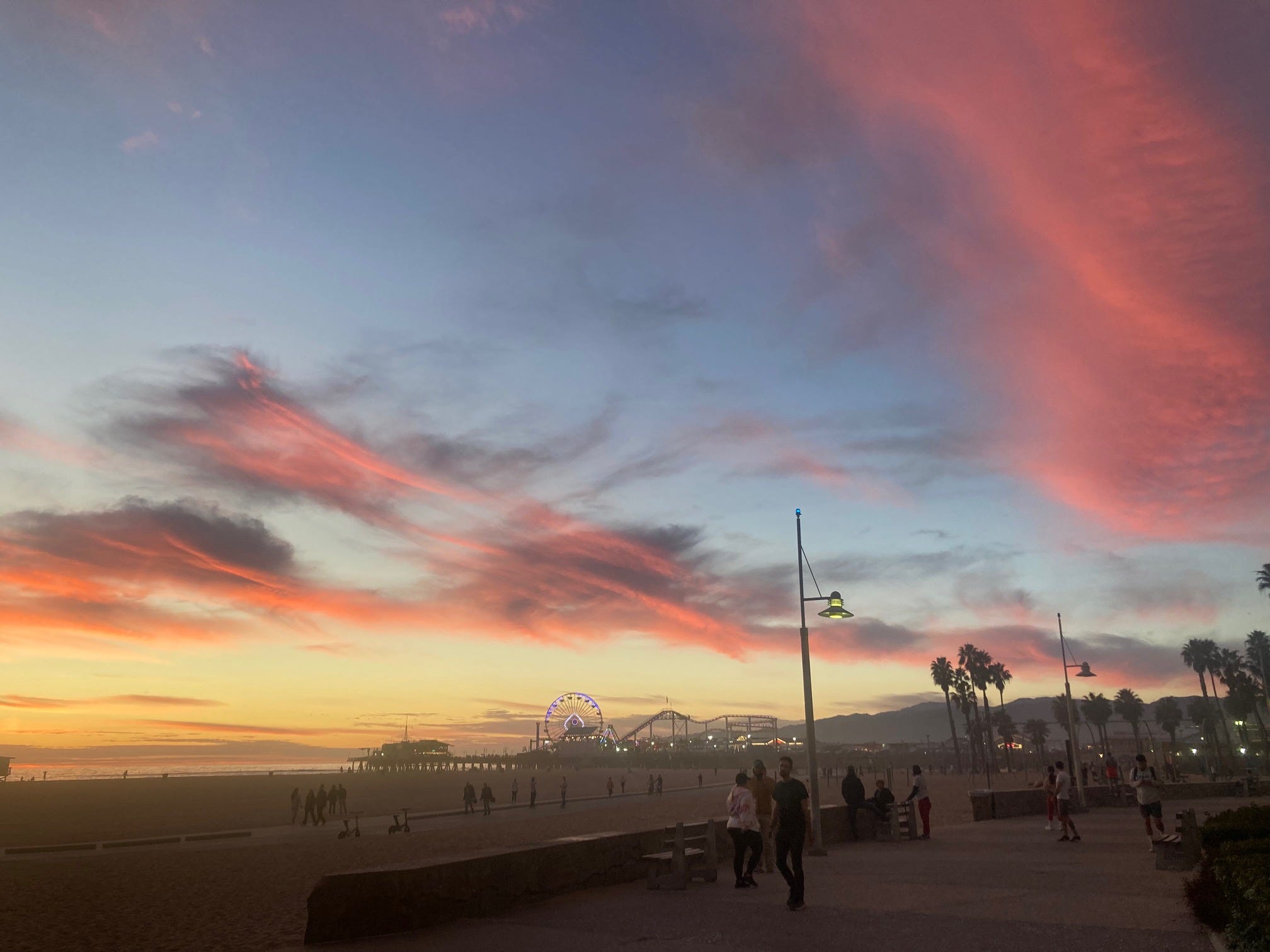 A sunset sky above the beach and the famous pier at Santa Monica, California.