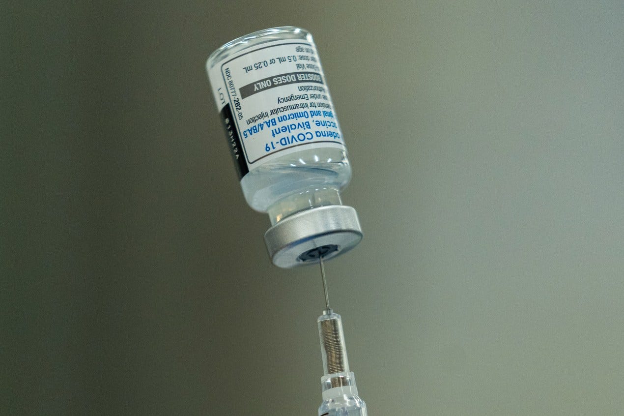 A close-up photo of a syringe inserted into a vial. A close-up photo of a syringe inserted into a vial.