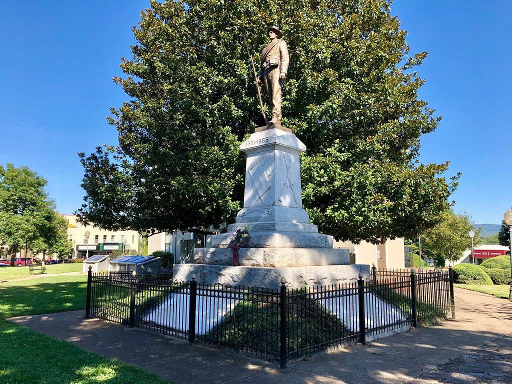 A photo of a Confederate statue atop of a stone pedestal in Downtown Morganton.