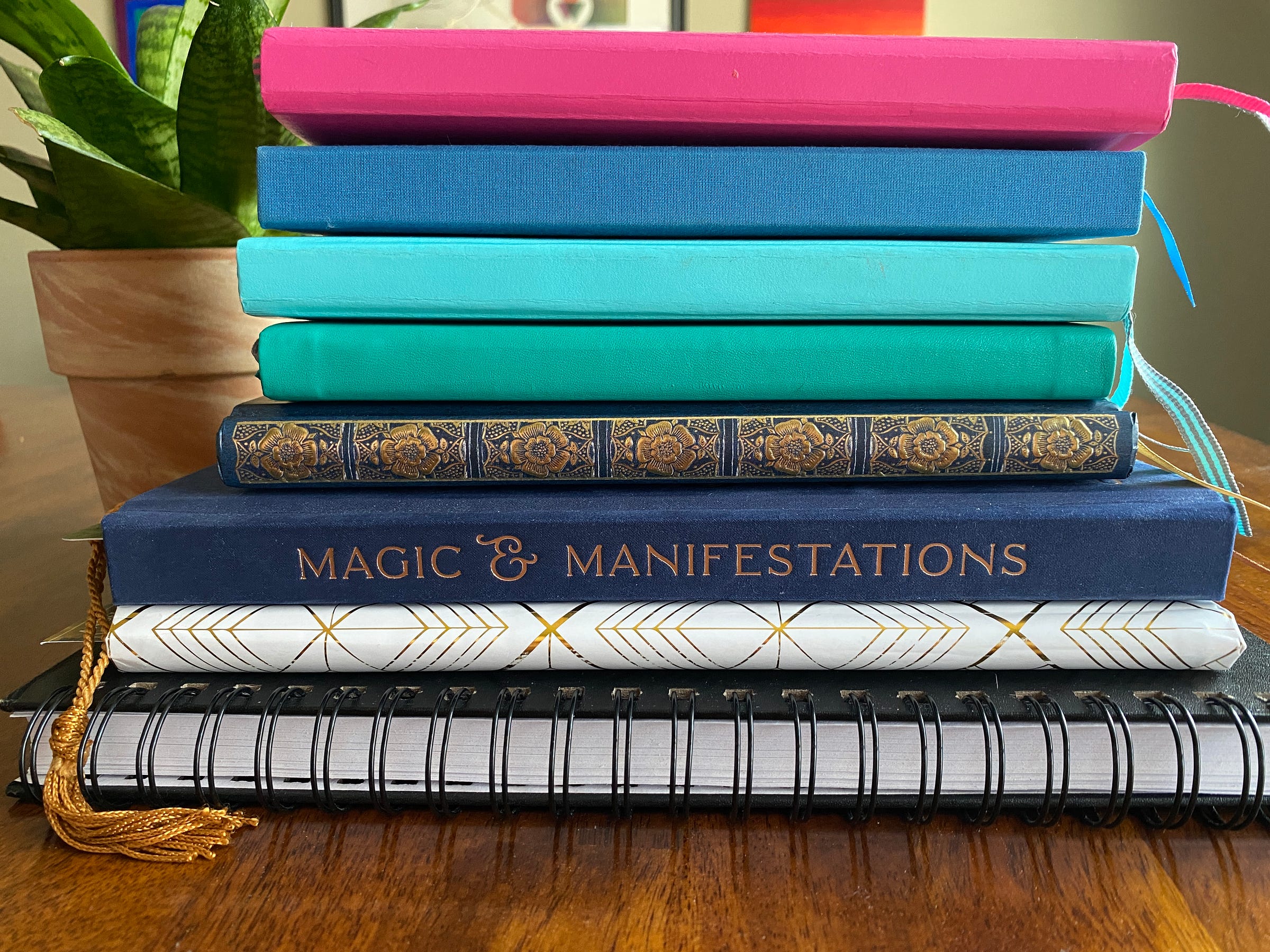 A stack of the author's journals: day planners, grimoires, morning pages, and more
