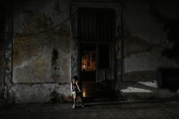 A resident sits while passing the time during the blackout in Havana, Cuba, on Saturday 19 October 2024 