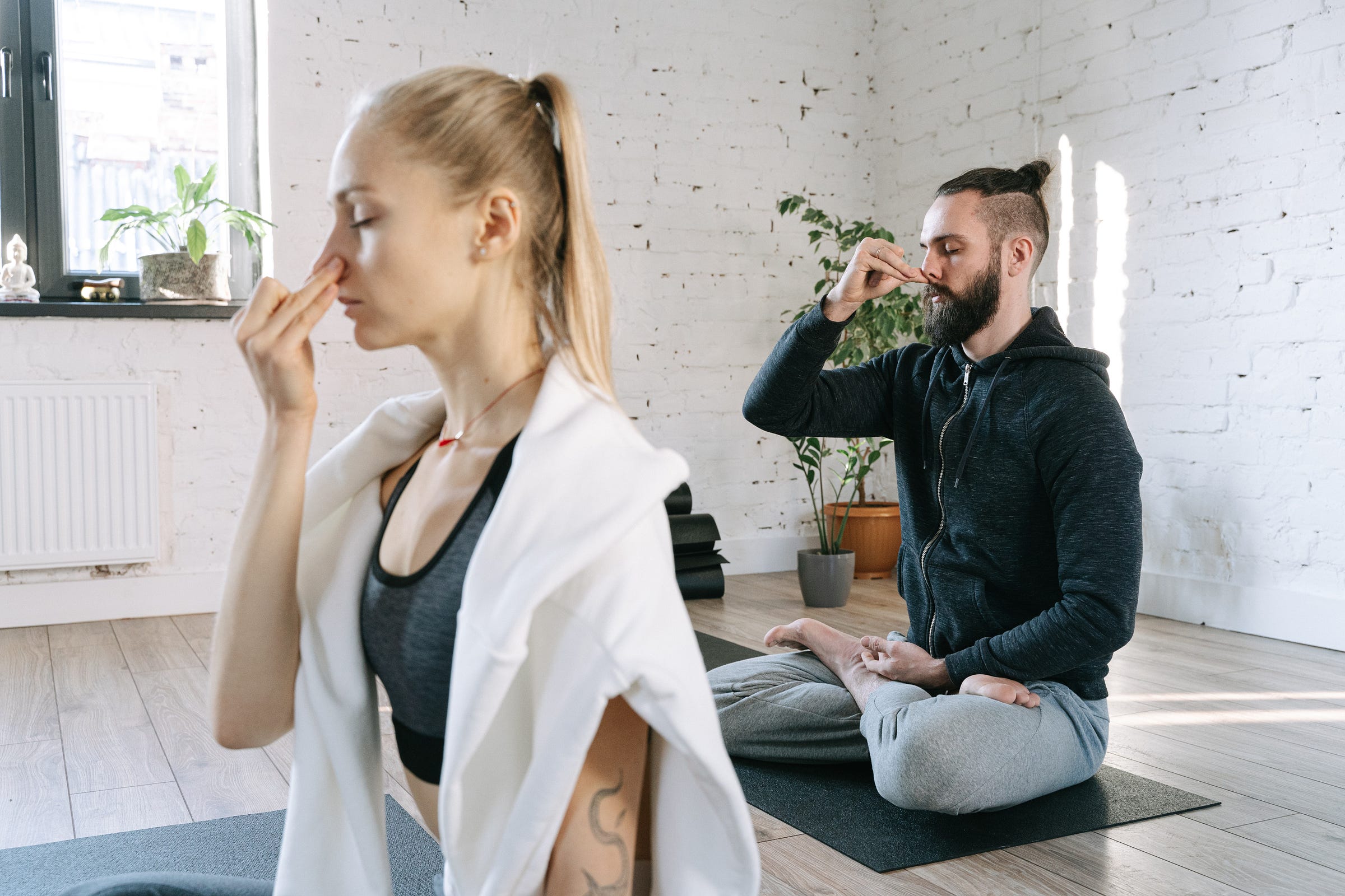 man and woman doing breathing exercises and yoga