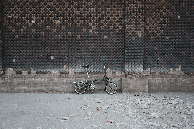 Vélo brompton contre un mur gris