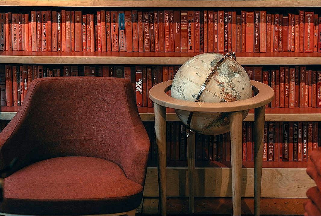 a chair and table in front of a bookshelf a chair and table in front of a bookshelf