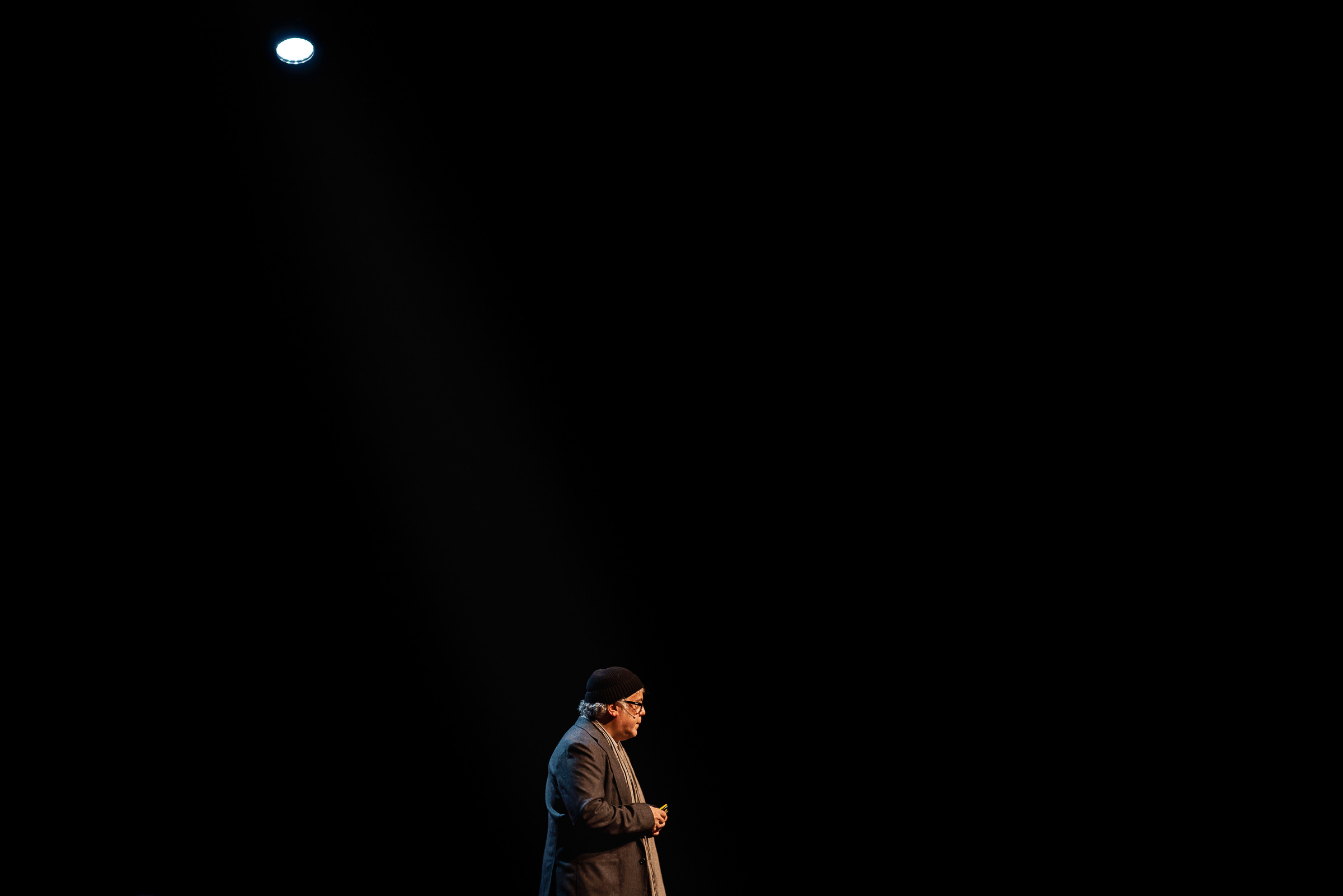 Photographer Ron Haviv isolated in a spotlight, on stage at a TED conference in 2021. 1/80, f/2.8, ISO 100, 35mm Photographer Ron Haviv isolated in a spotlight, on stage at a TED conference in 2021. 1/80, f/2.8, ISO 100, 35mm