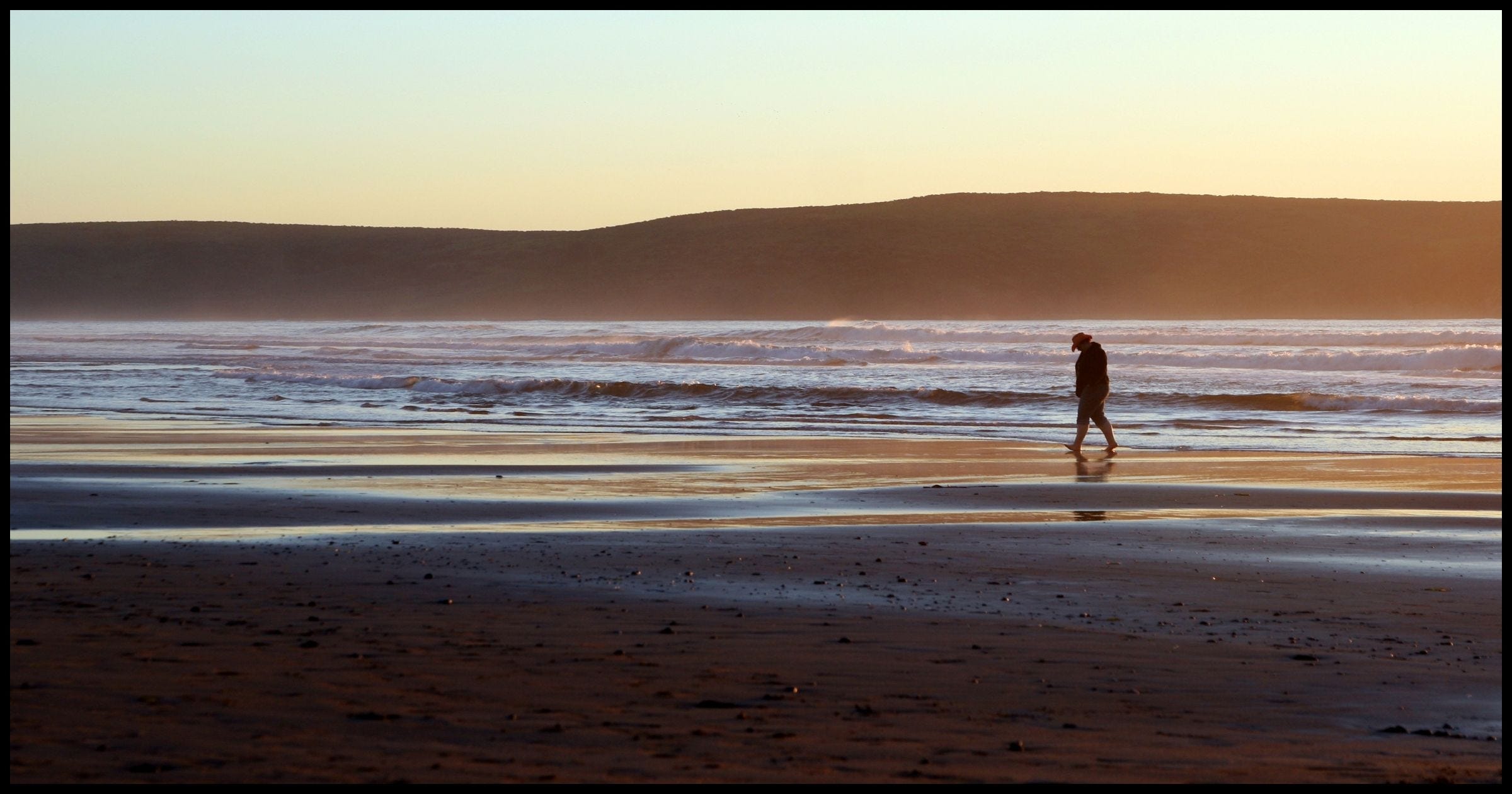 A person walking on a beach.