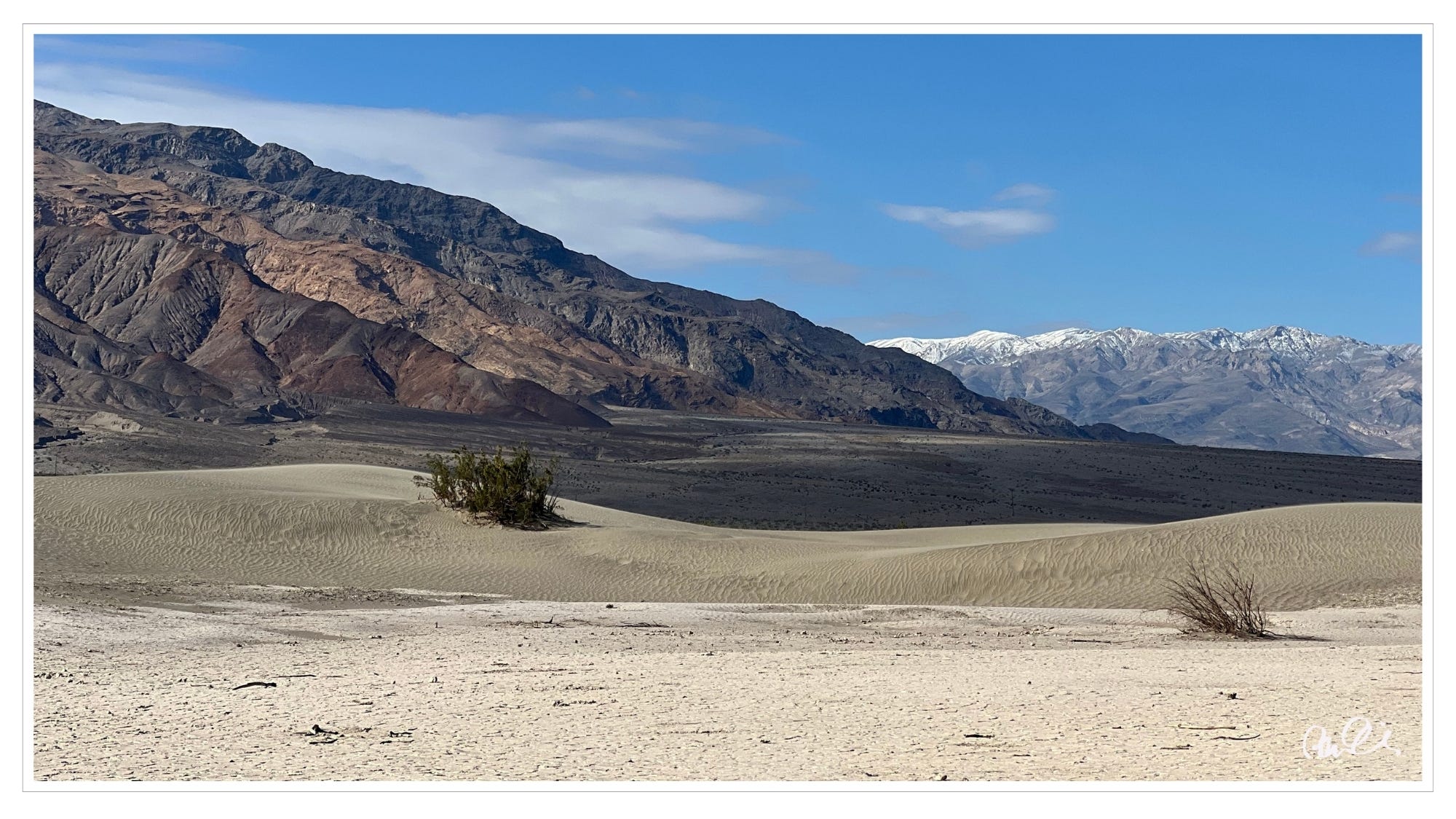 Sand dunes, distant snow-covered mountain ranges, Death Valley National Park