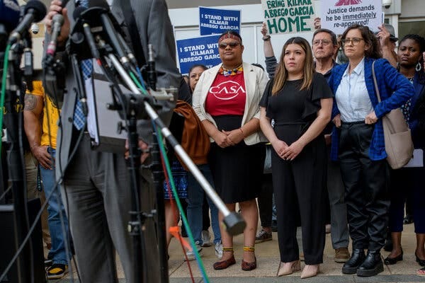 A group of people stands in front of cameras and microphones. A group of people stands in front of cameras and microphones.