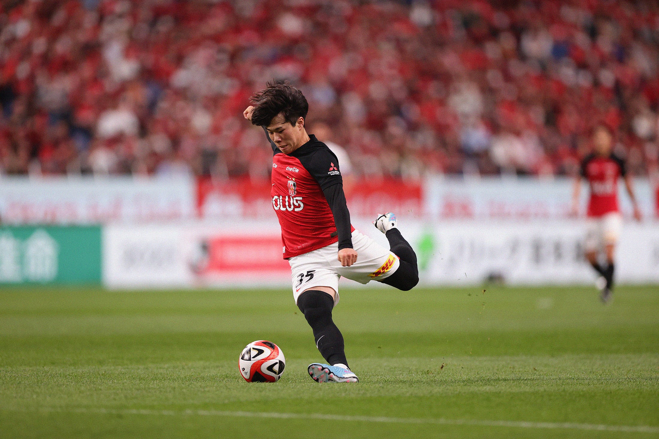 A photo of Urawa Red Diamonds' Jumpei Hayakawa in the action of striking the ball with his left foot.