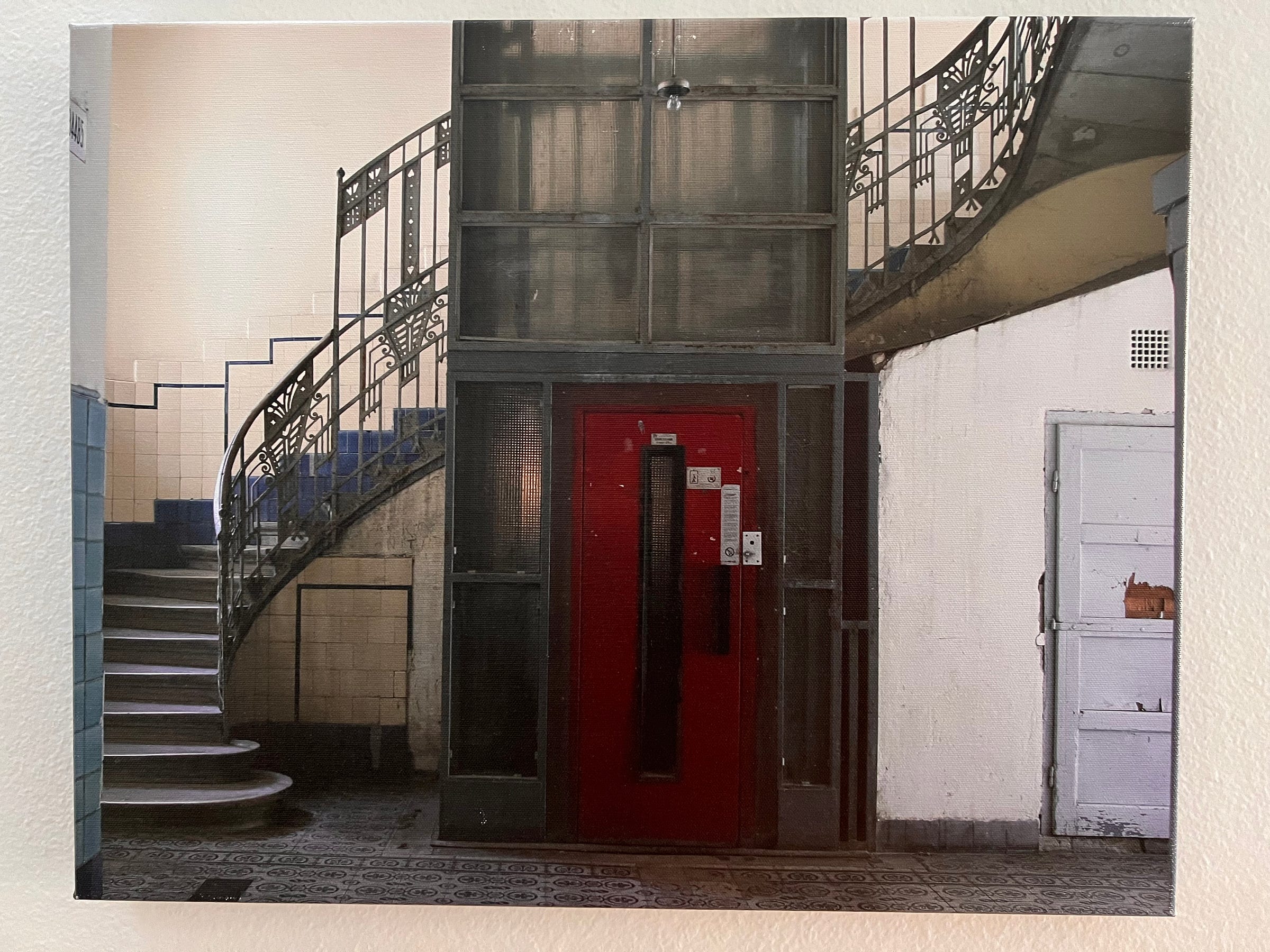 A photograph of a red door to an elevator in Budpest.