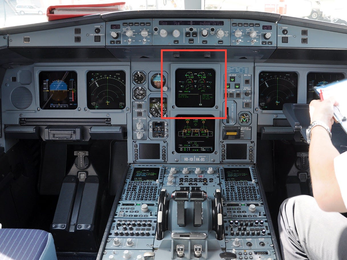 Cockpit of the A330. All instruments and displays are switched on. Two seats occupy both sides of the cockpit, separated by a centre console.