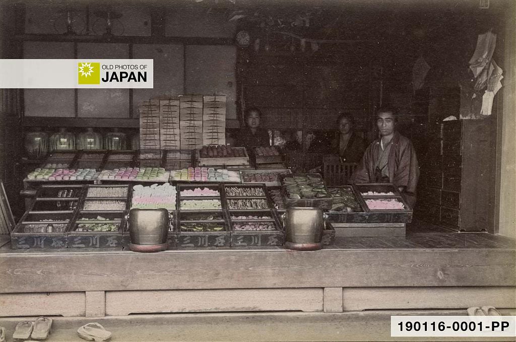 Japanese confectionery shop with hibachi charcoal braziers at the entrance, 1890s Japanese confectionery shop with hibachi charcoal braziers at the entrance, 1890s