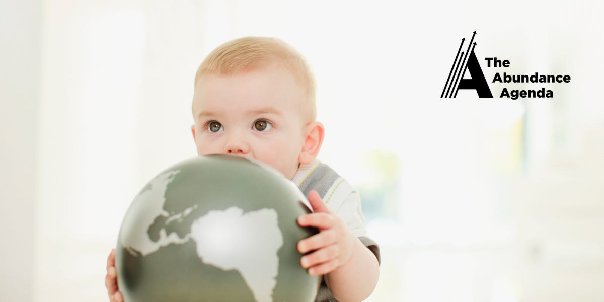 A baby gnaws on a globe.