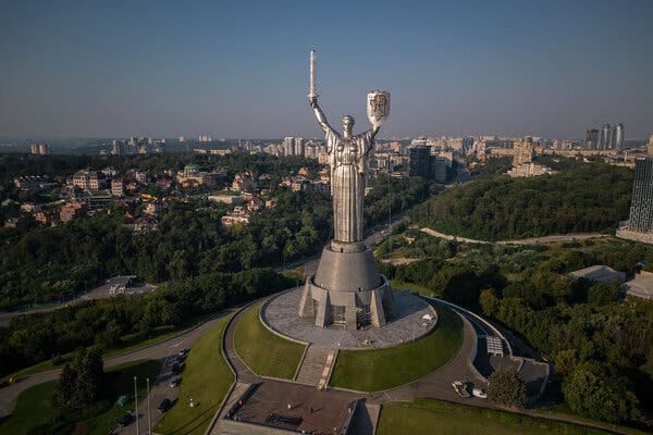 The Motherland Monument, a huge female figure, seen from slightly above with a city skyline spread out below.