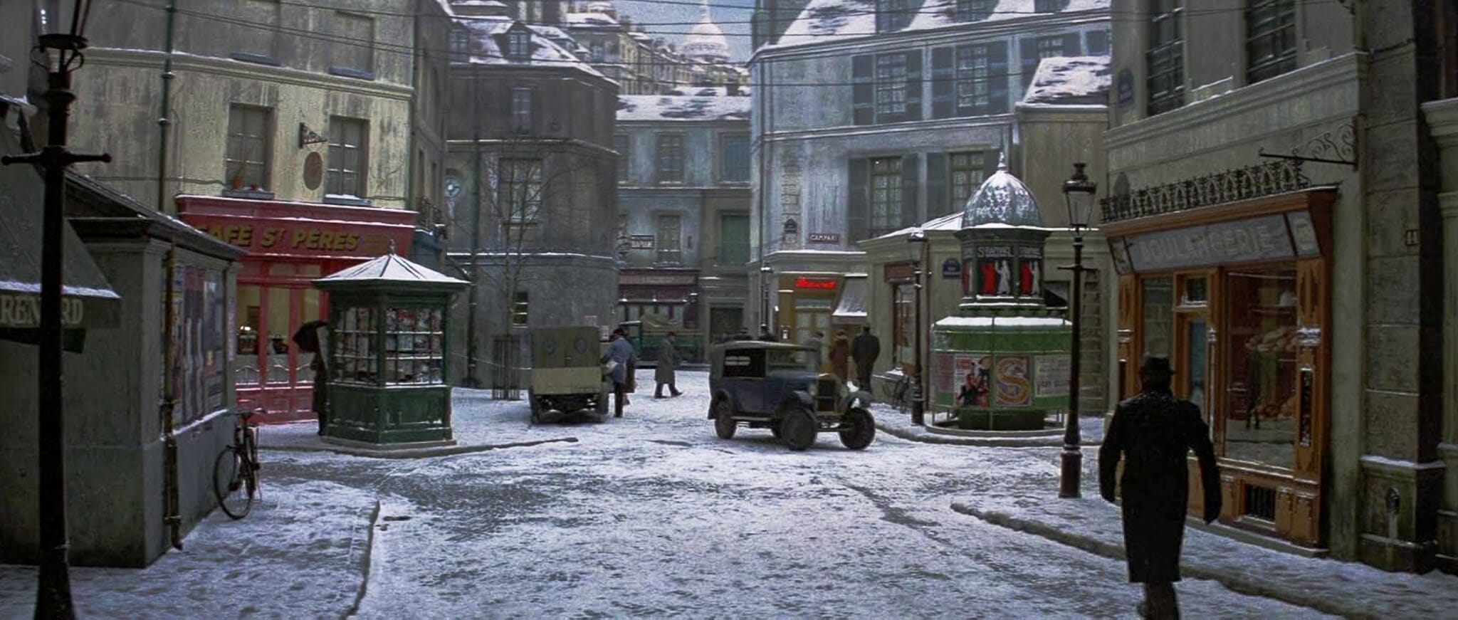 A dreamy re-creation of 1930s Paris under snowfall: cobblestone streets, vintage cars, glowing signage, and rows of detailed building facades on a soundstage. A dreamy re-creation of 1930s Paris under snowfall: cobblestone streets, vintage cars, glowing signage, and rows of detailed building facades on a soundstage.