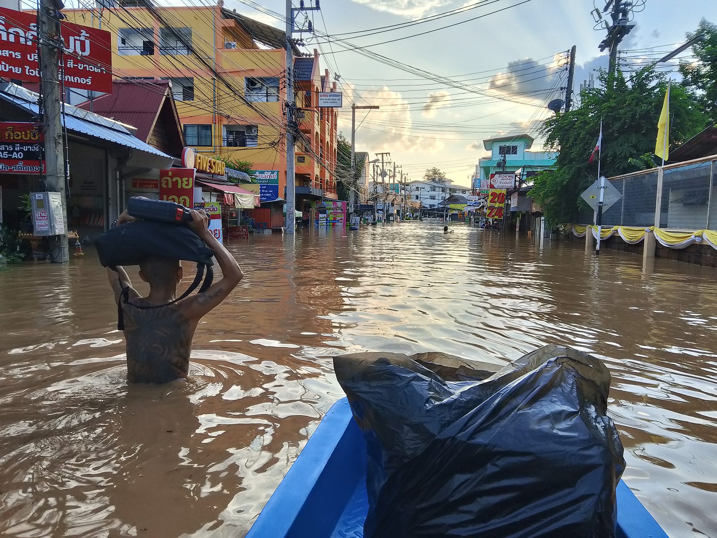 Evacuating Chiang Mai flooding in a tiny boat containing all our belongings wrapped in black plastic bags