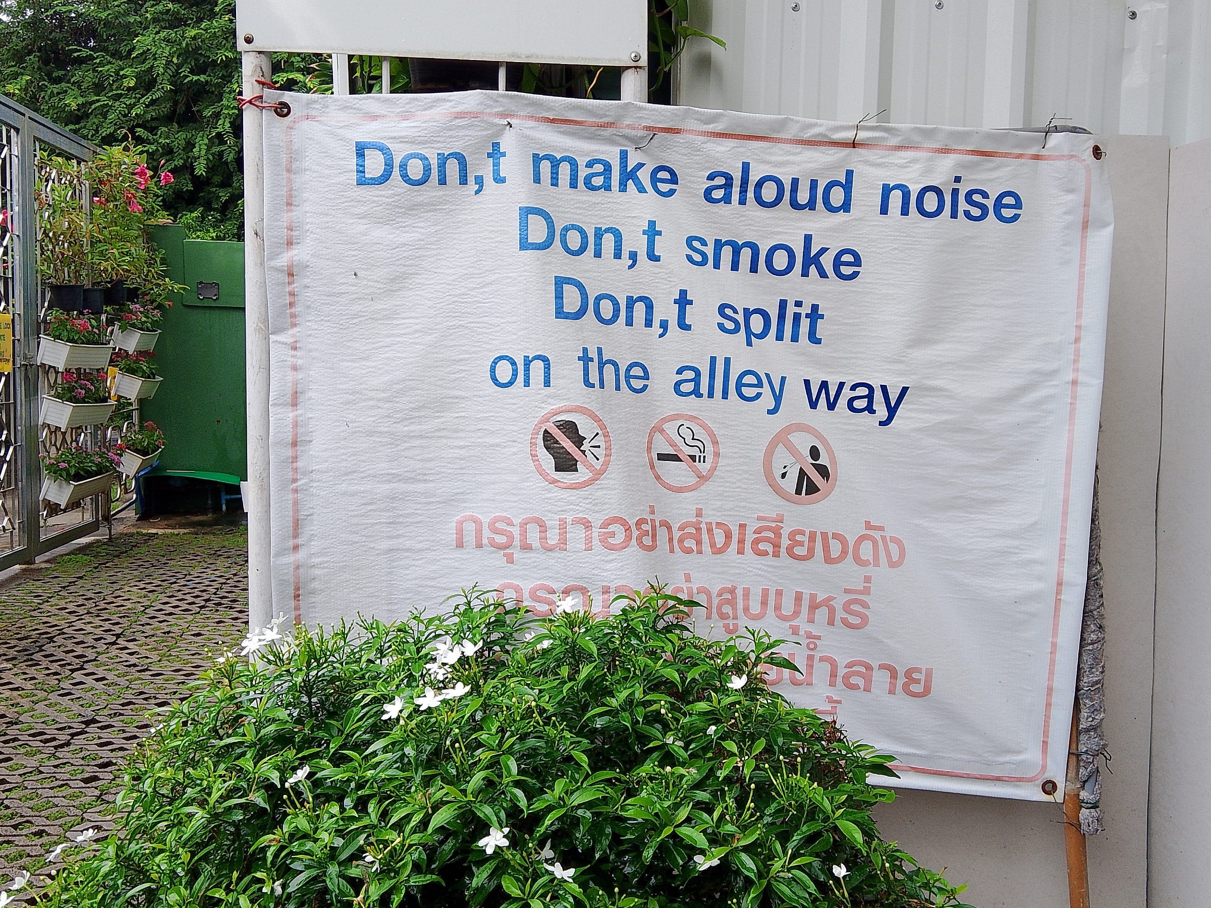 Thai sign in English that says: Don,t make aloud noise, Don,t smoke, Don,t split on the alley way