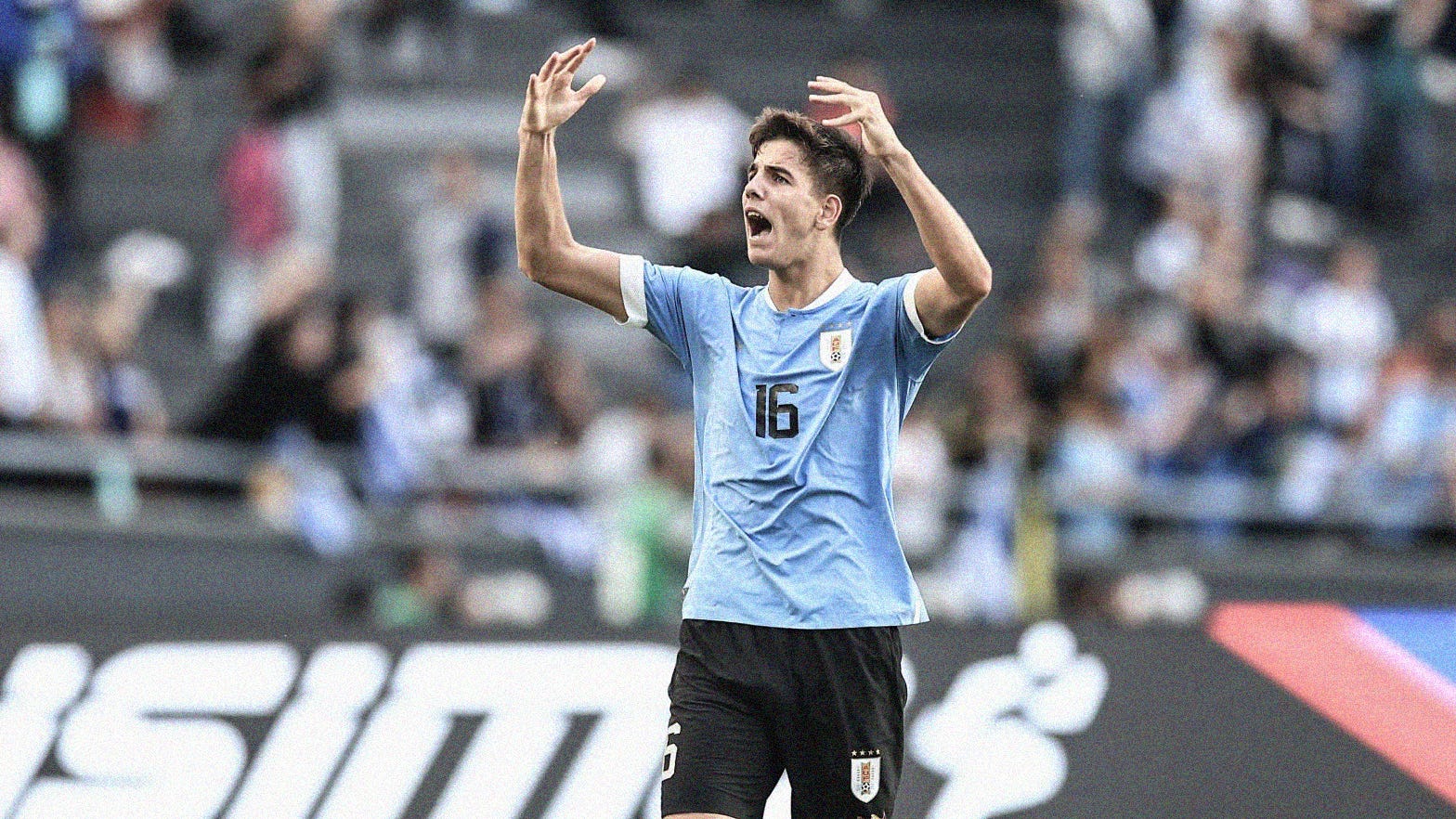 A photo of Uruguay's Facundo González waving his arms to hype up the fans at the 2023 FIFA U-20 World Cup