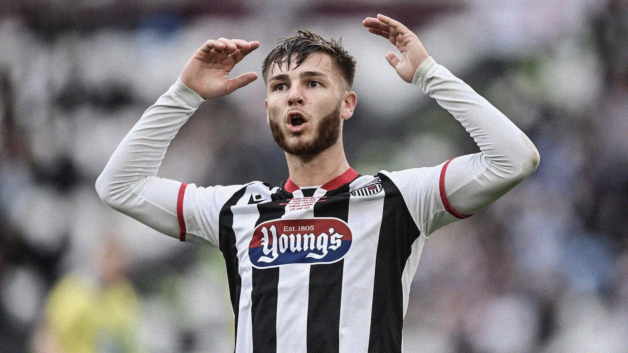 An upper-body photo of John McAtee looking perplexed with his arms in the air while playing for Grimsby Town